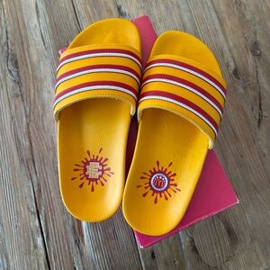 Eric Emanuel Adidas slides with yellow and red stripes.